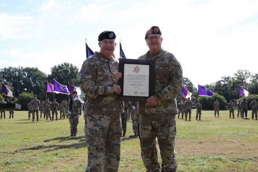 Retired Maj. Gen. Darrell Guthrie, former U.S. Army Civil Affairs and Psychological Operations Command (AIRBORNE) commanding general, presents Maj. Gen. Jeffrey C. Coggin with his certificate of retirement at the USACAPOC(A) joint Change of Command, Change of Responsibility, Retirement Ceremony held at the main post parade field, Ft. Bragg, NC., August 13, 2022. (U.S. Army Reserve photo by Pfc. Anthony Till)