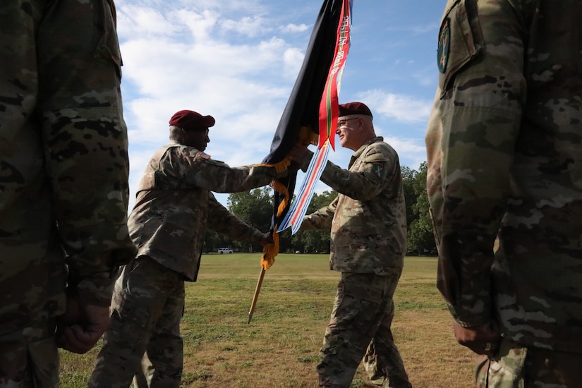Outgoing Command Sgt. Maj. Peter Trotter, passes the U.S. Army Civil Affairs and Psychological Operations Command (AIRBORNE) colors to retiring commanding general, Maj. Gen. Jeffrey Coggin during the joint Change of Command, Change of Responsibility, Retirement Ceremony held at the main post parade field, Ft. Bragg, NC., August 13, 2022. (U.S. Army Reserve photo by Pfc. Anthony Till)