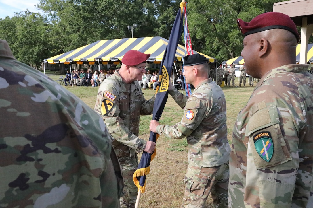 Retiring commanding general, Maj. Gen. Jeffrey Coggin, passes the U.S. Army Civil Affairs and Psychological Operations Command (AIRBORNE) colors to Maj. Gen. Michael D. Roache, U.S. Army Reserve Command chief of staff, during the USACAPOC(A) joint Change of Command, Change of Responsibility, Retirement Ceremony held at the main post parade field, Ft. Bragg, NC., August 13, 2022. (U.S. Army Reserve photo by Pfc. Anthony Till)