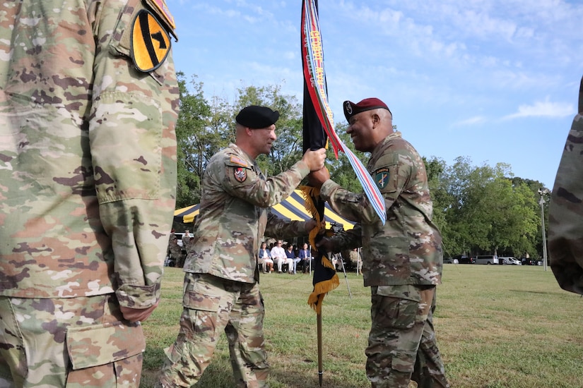 Maj. Gen. Michael D. Roache, U.S. Army Reserve Command chief of staff, passes the U.S. Army Civil Affairs and Psychological Operations Command (AIRBORNE) colors to Maj. Gen. Isaac Johnson, Jr., signaling Johnson’s assumption of command as the 11th commanding general of USACAPOC(A) at the joint Change of Command, Change of Responsibility, Retirement Ceremony held August 13, 2022, at the main parade field, Ft. Bragg, NC. (U.S. Army Reserve photo by Pfc. Anthony Till)