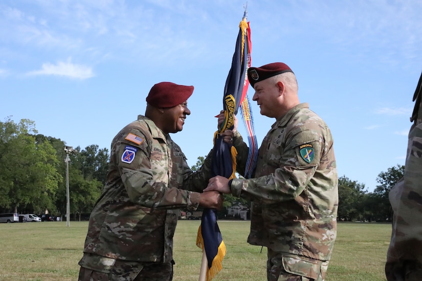 Maj. Gen. Isaac Johnson, Jr. passes the U.S. Army Civil Affairs and Psychological Operations Command (AIRBORNE) colors to incoming Command Sgt. Maj. Daniel Benedict, signaling Benedict’s assumption of responsibility as the senior enlisted advisor for USACAPOC(A) at the joint Change of Command, Change of Responsibility, Retirement Ceremony held August 13, 2022, at the main parade field, Ft. Bragg, NC. (U.S. Army Reserve photo by Pfc. Anthony Till)