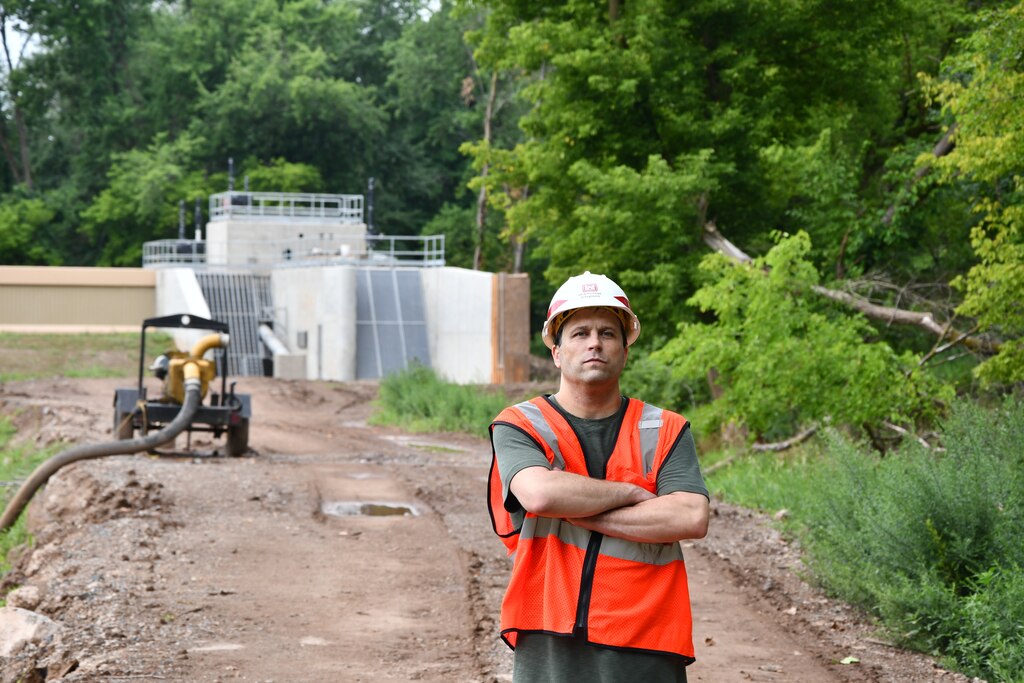 Alek Petersen, project manager for the Green Brook Flood Risk Management Project, stands within the interior, protected side of a floodwall and pump station system in Middlesex, New Jersey.