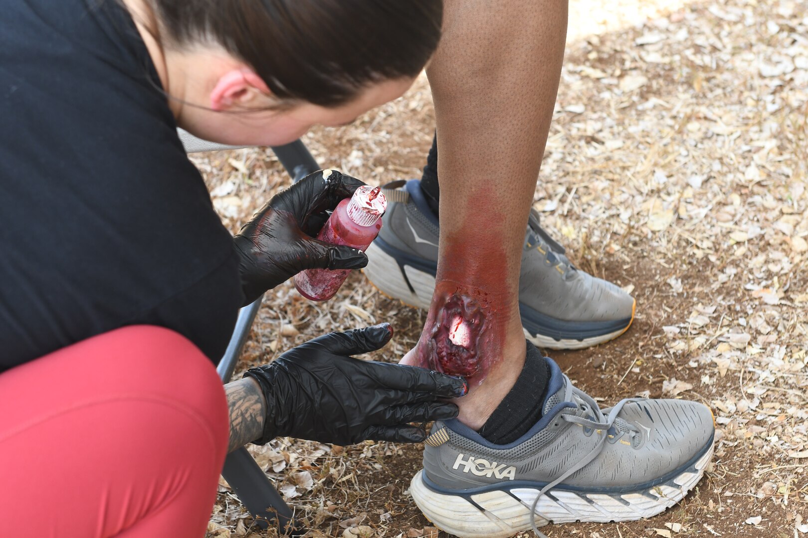 Fake blood and injury is applied to ankle.