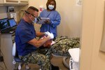 Dentist performs dental exam on patient.
