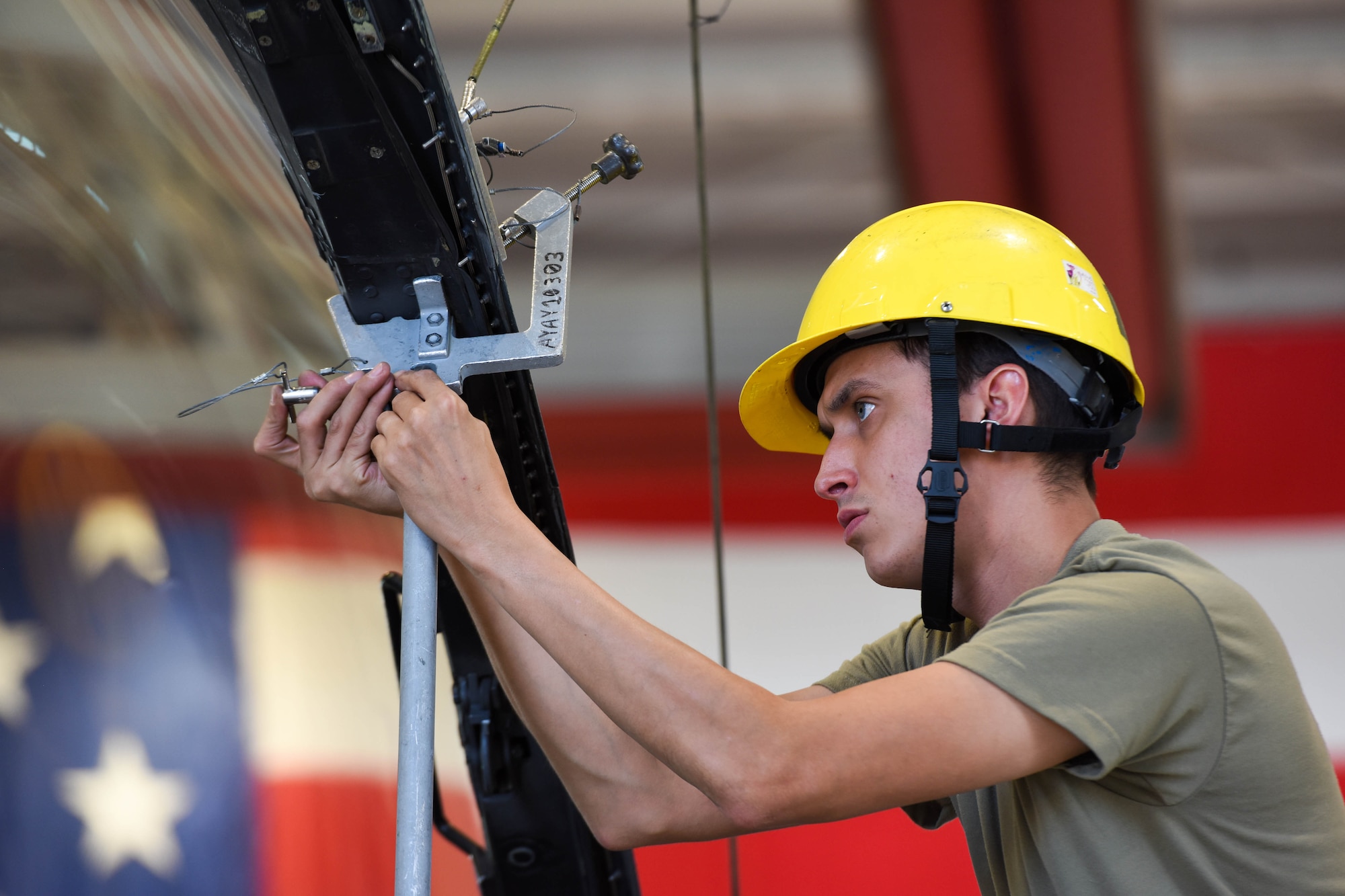 Senior Airman Andres Espinoza, 31st Maintenance Squadron Egress journeyman, pins a canopy support strut on an F-16 Fighting Falcon at Aviano Air Base, Italy, Aug. 11, 2022. Egress specialists perform inspections and maintenance on F-16 Fighting Falcon canopies and egress systems to ensure the components function properly in flight and during emergencies. (U.S. Air Force photo by Senior Airman Brooke Moeder)