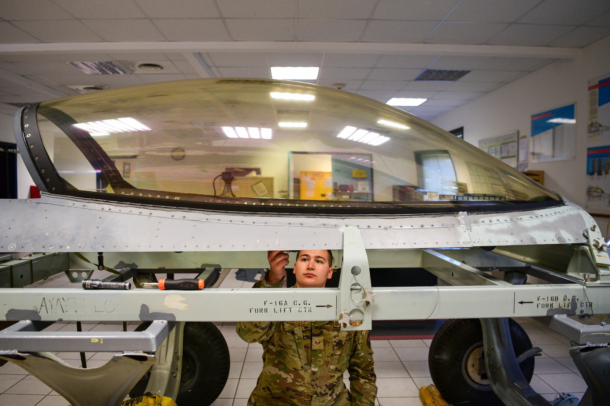 Senior Airman Reece Kutzli, 31st Maintenance Squadron Egress journeyman, screws bolts into an F-16 Fighting Falcon canopy at Aviano Air Base, Italy, Aug. 10, 2022. 31st MXS Egress specialists ensure the safety of pilots, making sure that if an aircraft ever goes down, the pilot is safe. (U.S. Air Force photo by Senior Airman Brooke Moeder)