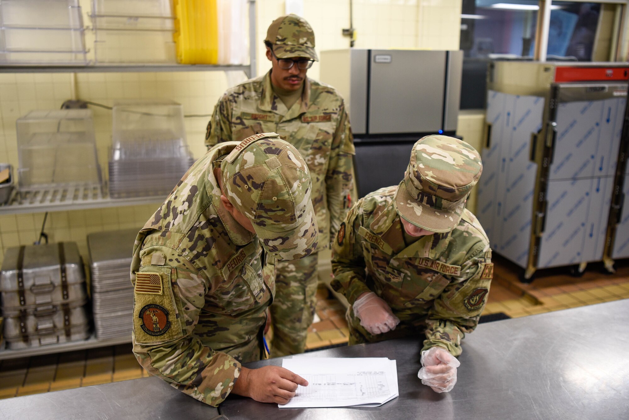 U.S. Air Force Airman 1st Class Shawn Pedrus and U.S. Air Force Angelina Frenzel, food service members with the 36th Force Support Squadron, go through a checklist at Andersen Air Force Base, Guam, July 28, 2022. Pedrus and Frenzel checked to see what else they needed to prepare for the meal ahead.(U.S. Air Force photo by Airman 1st Class Allison Martin)
