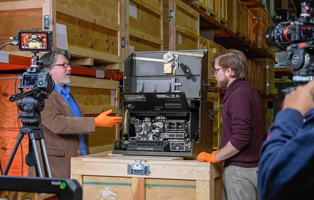 Rob Simpson, left, and Spencer Allenbaugh, right, the National Cryptologic Museum’s librarian and collections manager, respectively, discuss one of the uncrated artifacts recently rediscovered in an NSA warehouse a few miles from NSA-Washington in Maryland.