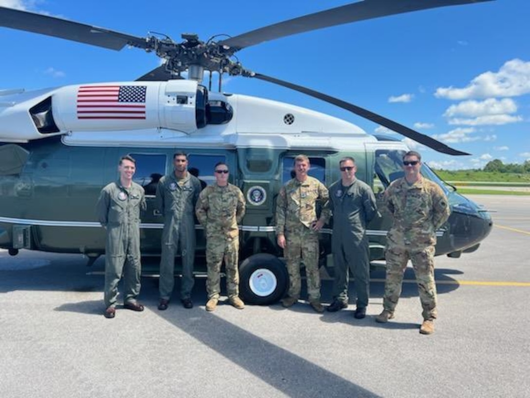 Army Sgt. William ‘Cecil’ Harris, a fuel Supply specialist with Detachment 1, Carlie Co. 2-238th Aviation- ‘Wildcat DUSTOFF’ poses for a group photo in front of his the presidential Sikorsky VH-60 helicopter, Marine One, prior to President Joe Biden using it to view the damage causes by the historic flooding in Eastern Kentucky.