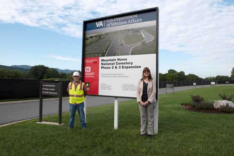 Nathan Alford, engineer technician and construction representative in the Nashville District’s Eastern Tennessee Resident Office in Knoxville; and Sue Nan Jehlen, Mountain Home National Cemetery director, pose by the expansion project sign during a site visit at the cemetery annex in Johnson, City, Tennessee, Aug. 10, 2022. (USACE Photo by Lee Roberts)