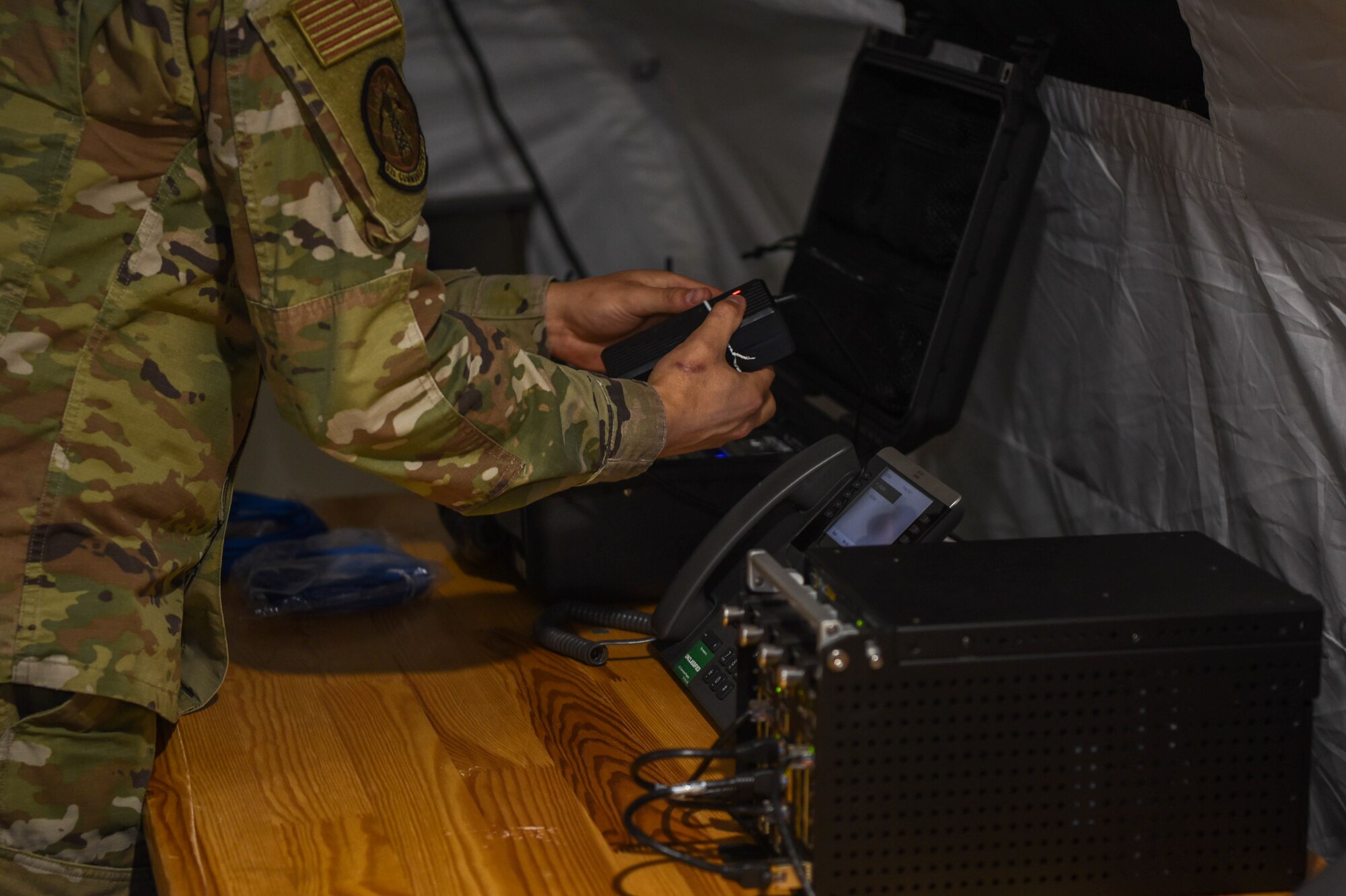 Service members install a data usage source in a Project Arcwater tent.