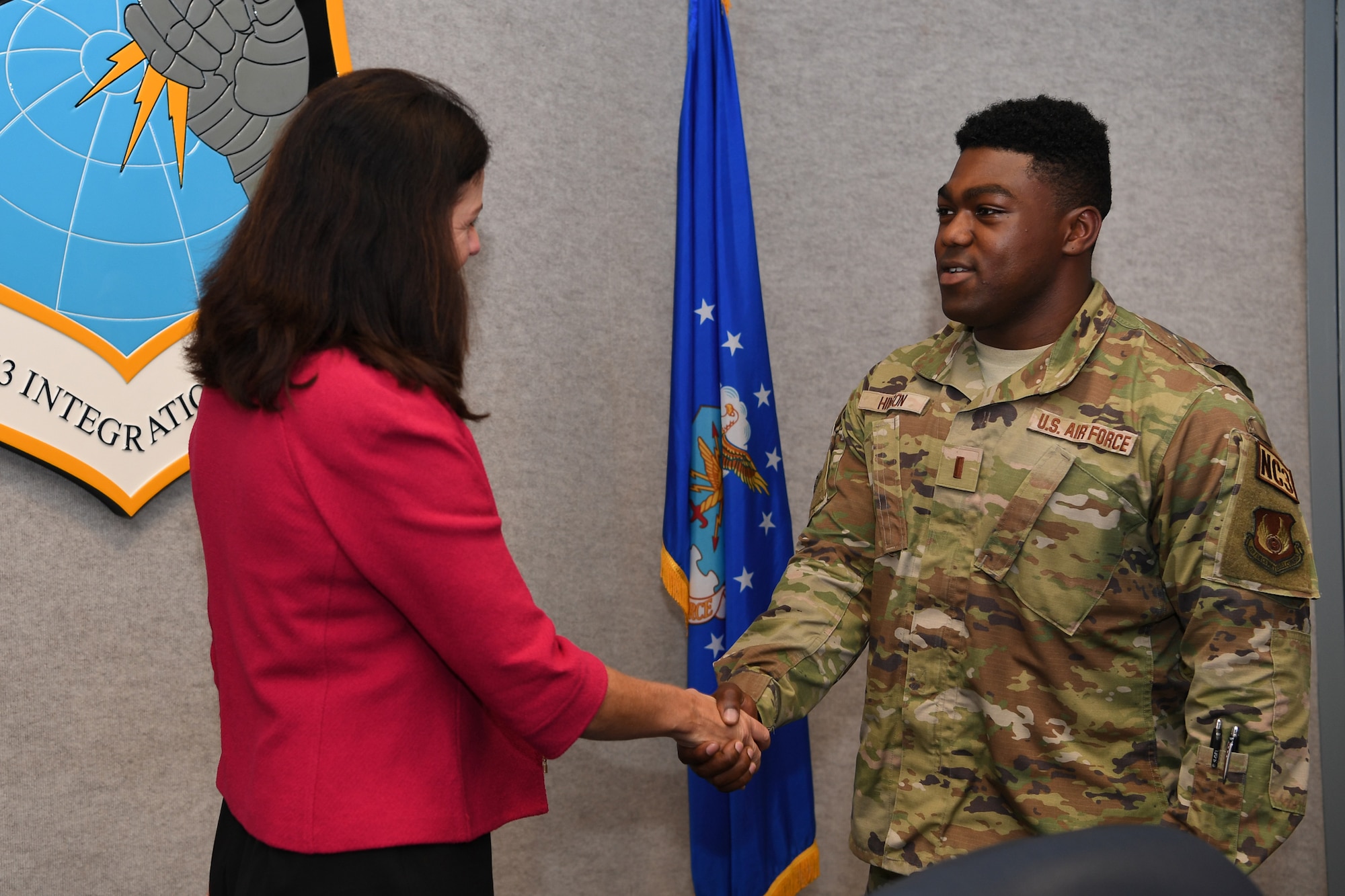 Woman shaking hands with Airman