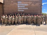 photo of a large group of military members in front of building that says 942 Distributed Mission Operations center