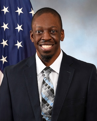 Portrait of a man in front of an American flag.