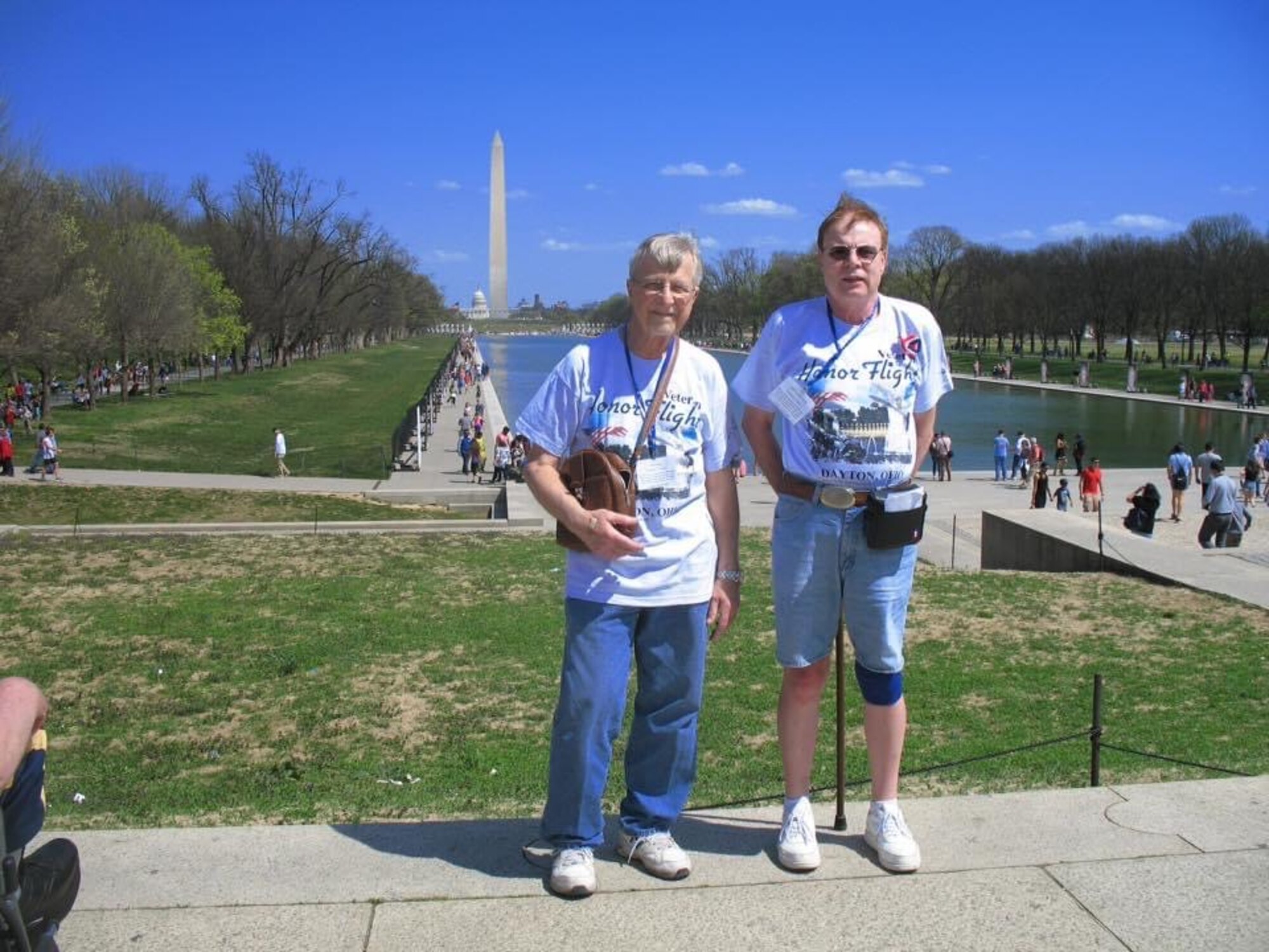 Two veterans with the Honor Flight Dayton stop for a photo with the Washington Monument during their tour.
