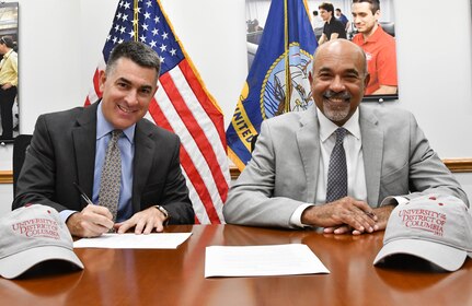 IMAGE: Naval Surface Warfare Center Dahlgren Division (NSWCDD) Technical Director Dale Sisson Jr., SES, and University of the District of Columbia (UDC) President Ronald Mason sign an Educational Partnership Agreement. The partnership provides NSWCDD support to the university while developing a future talent pool for the Navy from UDC students who are pursuing STEM-related degrees.