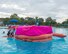 Large life raft floating in pool with pink cover, practicing signaling friendly aircraft.