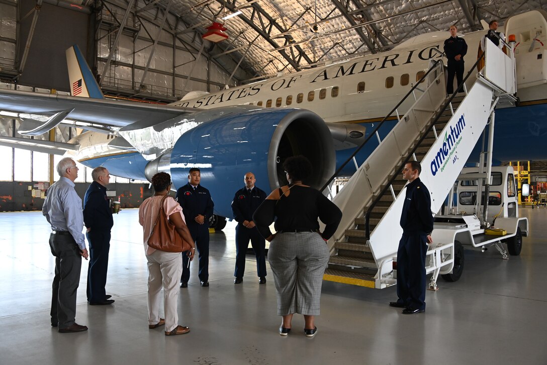 Two Airmen from the 89th Airlift Wing brief a group of honorary commanders and Joint Base Andrews leadership about the Boeing C-32 before boarding to tour the cabin and cockpit at Joint Base Andrews, Md., Aug. 16, 2022. The group toured the airfield and aircraft as part of an honorary commanders immersion event. (U.S. Air Force photo by Airman 1st Class Isabelle Churchill)