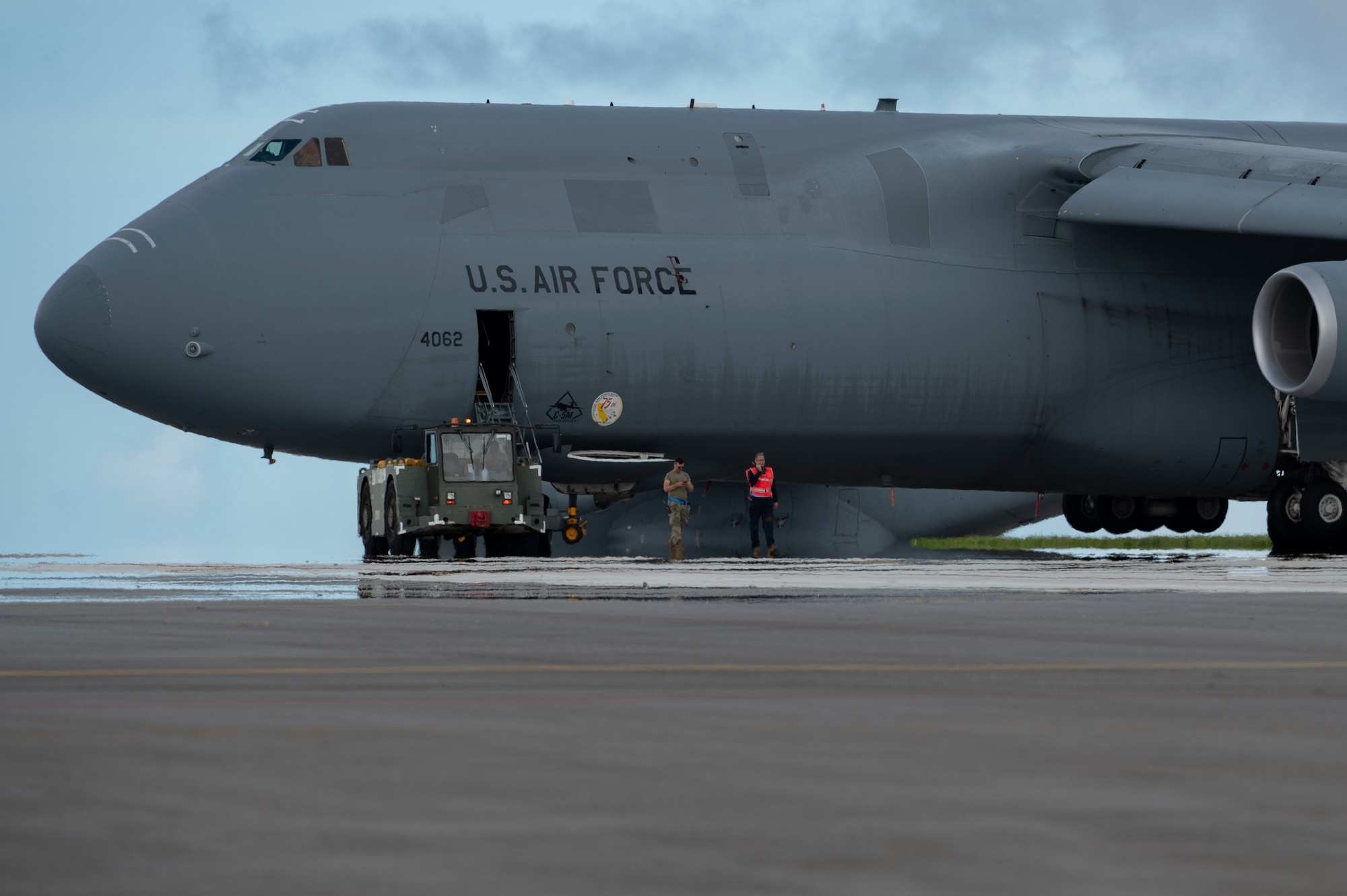 U.S. Air Force Airmen assigned to the 734th Air Mobility Squadron, Andersen Air Force Base, Guam, tow a U.S. Air Force C-5M Super Galaxy, July 13, 2022 at Andersen AFB. A team of instructors assigned to the 515th Air Mobility Operation Wing, Joint Base Pearl Harbor-Hickam, Hawaii, trained Airmen assigned at Andersen AFB on aircraft towing, jacking, and air force specialty code specific training. During this training, Airmen not specifically assigned to the C-5 received training and familiarization of the systems and capabilities of the aircraft. (U.S. Air Force Photo by Airman 1st Class Emily Saxton)