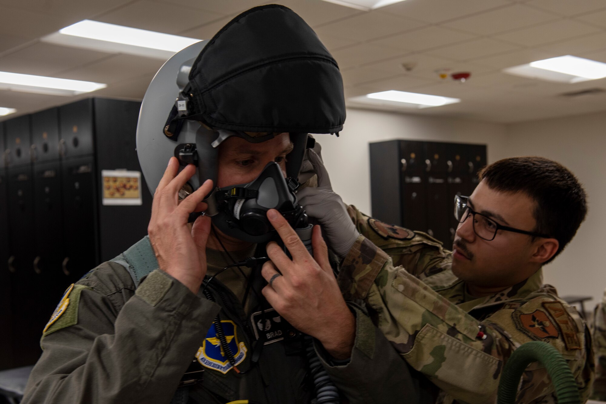 Airman 1st Class Gilberto Deleon helps Colonel Justin Spears with the adjustment of his helmet.