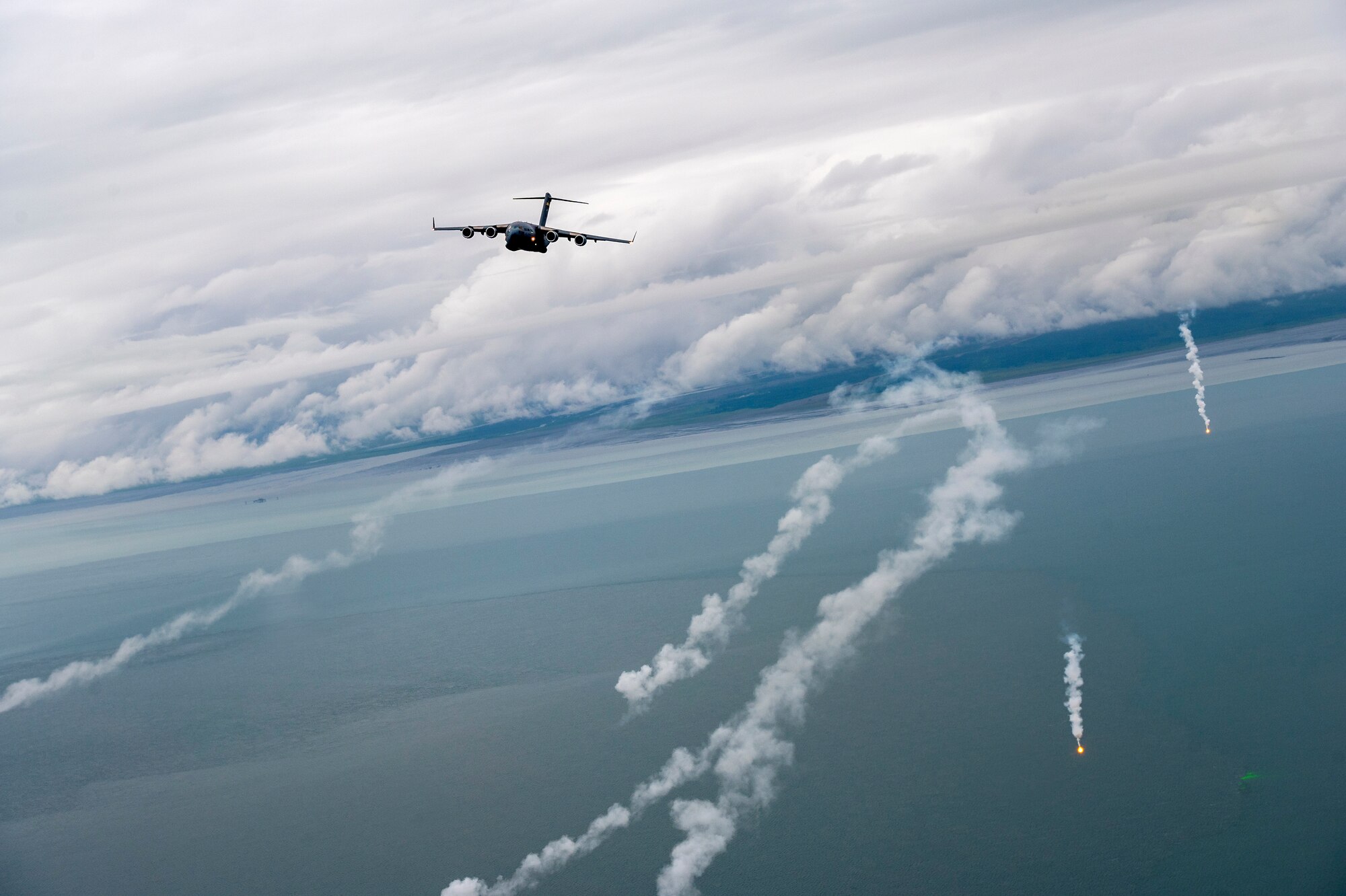 A U.S. Air Force C-17 Globemaster III, crewed by members of the 204th Airlift Squadron, conducts flare deployment training July 7, 2022, Kenai Peninsula Borough, Alaska.