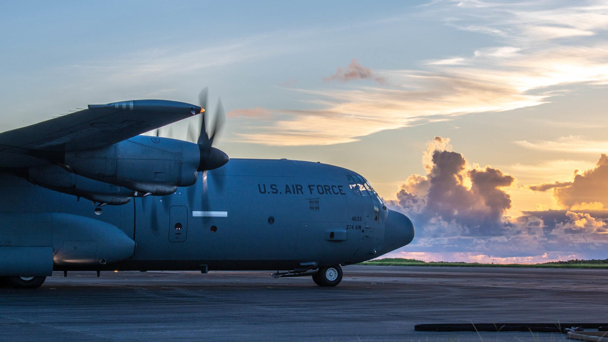 A C-130J Super Hercules sits on a flightline during sunset