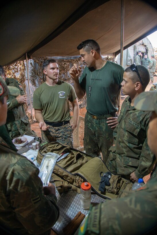 A U.S. Navy Corpsman with India Company, 3rd Battalion, 1st Marine Regiment, 1st Marine Division showcases his medical supplies kit for Brazilian Marines during Exercise Formosa, Aug. 5, 2022.