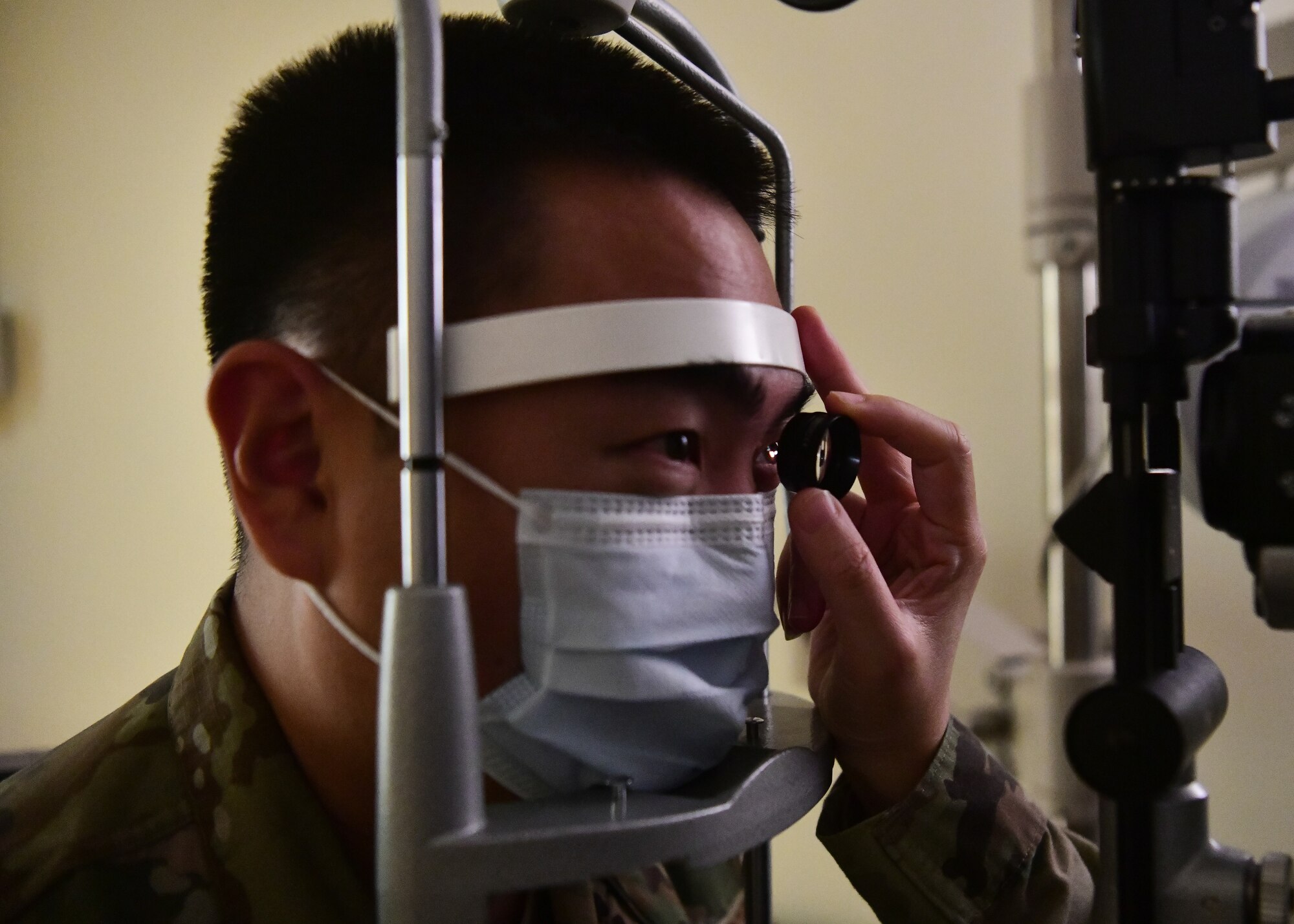 A military member has an eye exam conducted on them.