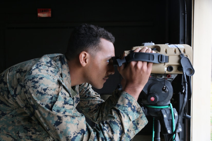 A Marine looks through a targeting system.