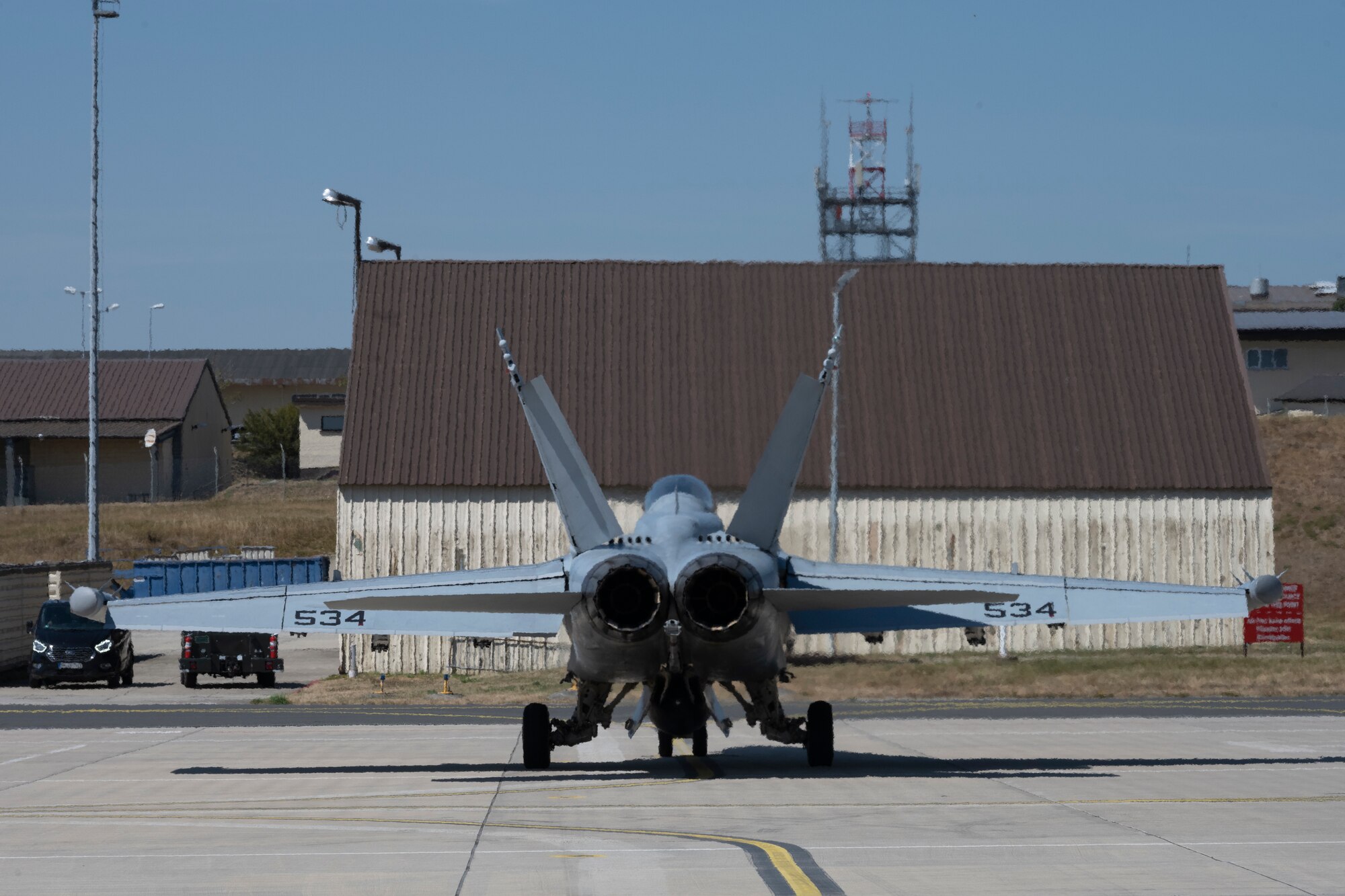 Service members participate in a joint hot-refueling on a electronic attack aircraft.