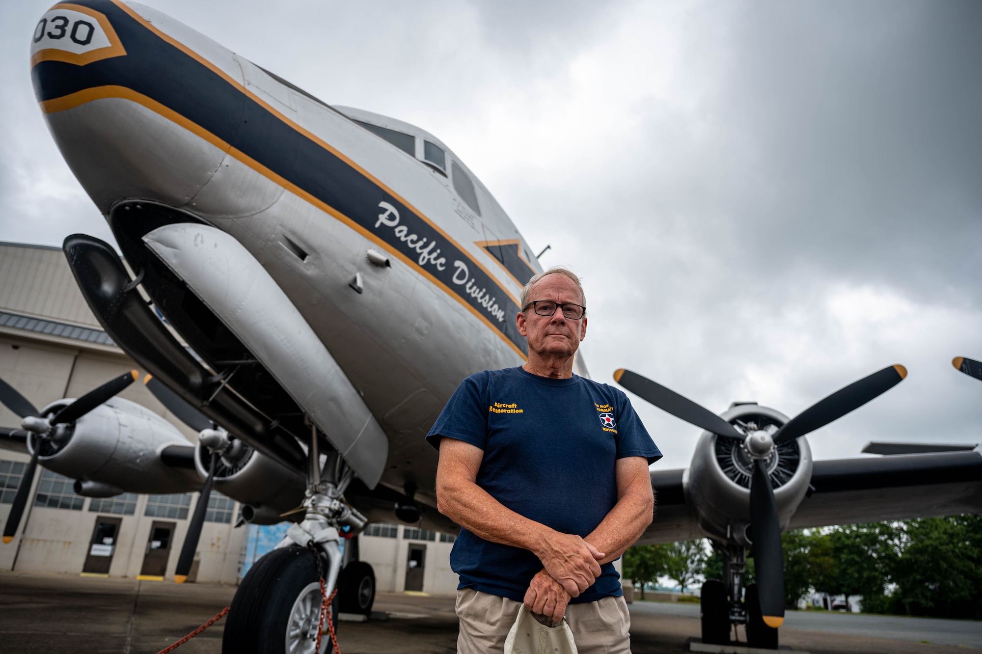 Timothy O’Donnell, Air Mobility Command Museum volunteer, poses for a photo in front of a C-54M Skymaster at Dover, Delaware, Aug. 1, 2022. O’Donnell is a retired internal doctor and now spends his time restoring aircraft at the AMC Museum. (U.S. Air Force photo by Senior Airman Faith Schaefer)