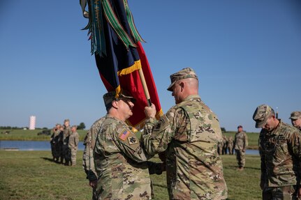 Col. Colby Wyatt, outgoing commander of the 45th Infantry Brigade Combat Team, Oklahoma National Guard, passes the unit colors to Brig. Gen. Thomas Mancino, adjutant general for Oklahoma, at a change of command ceremony, Camp Gruber Training Center, Oklahoma, Aug. 14, 2022. Wyatt served as the commander of the 45th IBCT for three years and relinquished command to Col. Andrew Ballenger. (Oklahoma Army National Guard photo by Spc. Danielle Rayon)