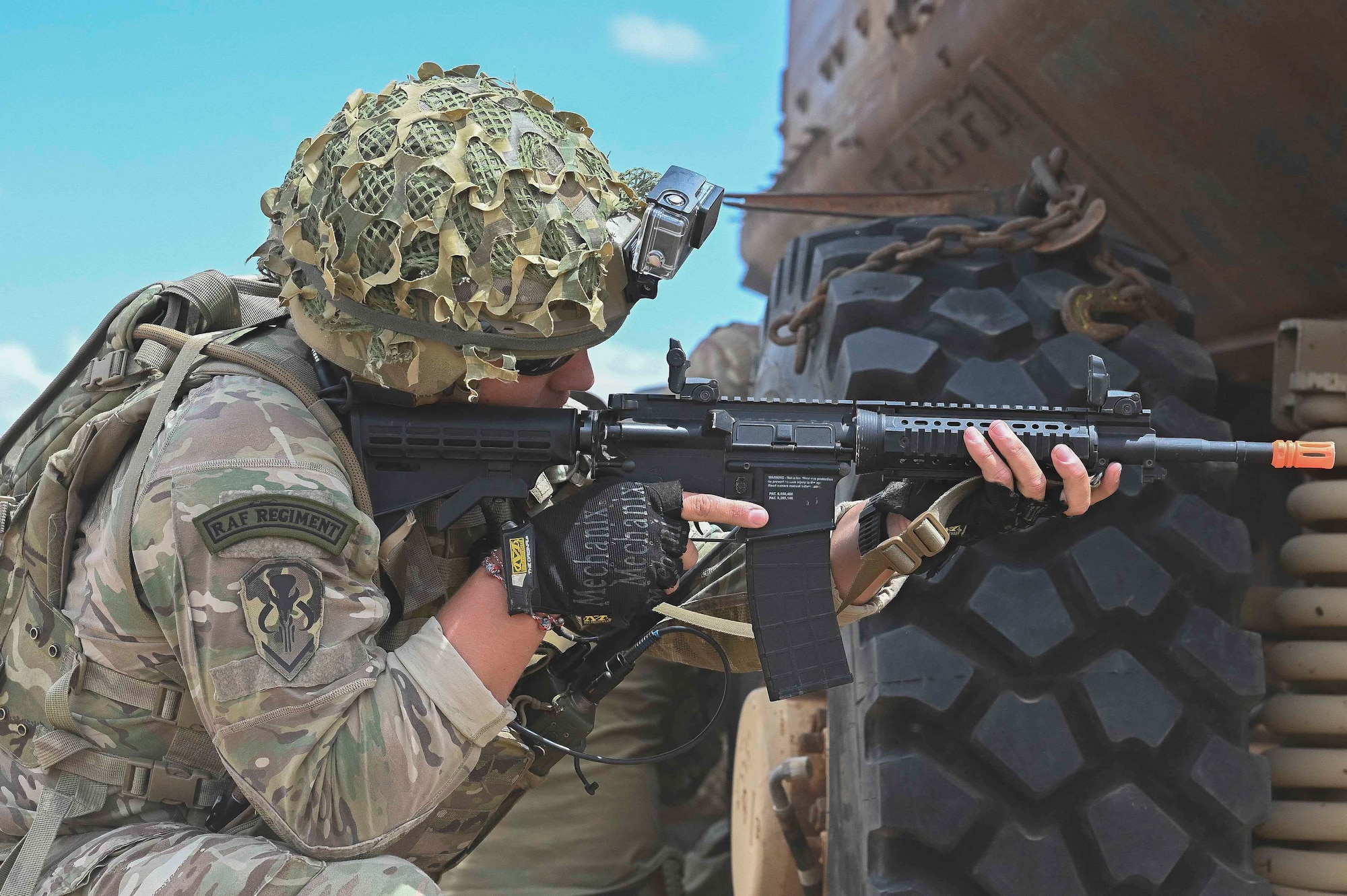 Pictured above is a man kneeling and pointing a weapon.