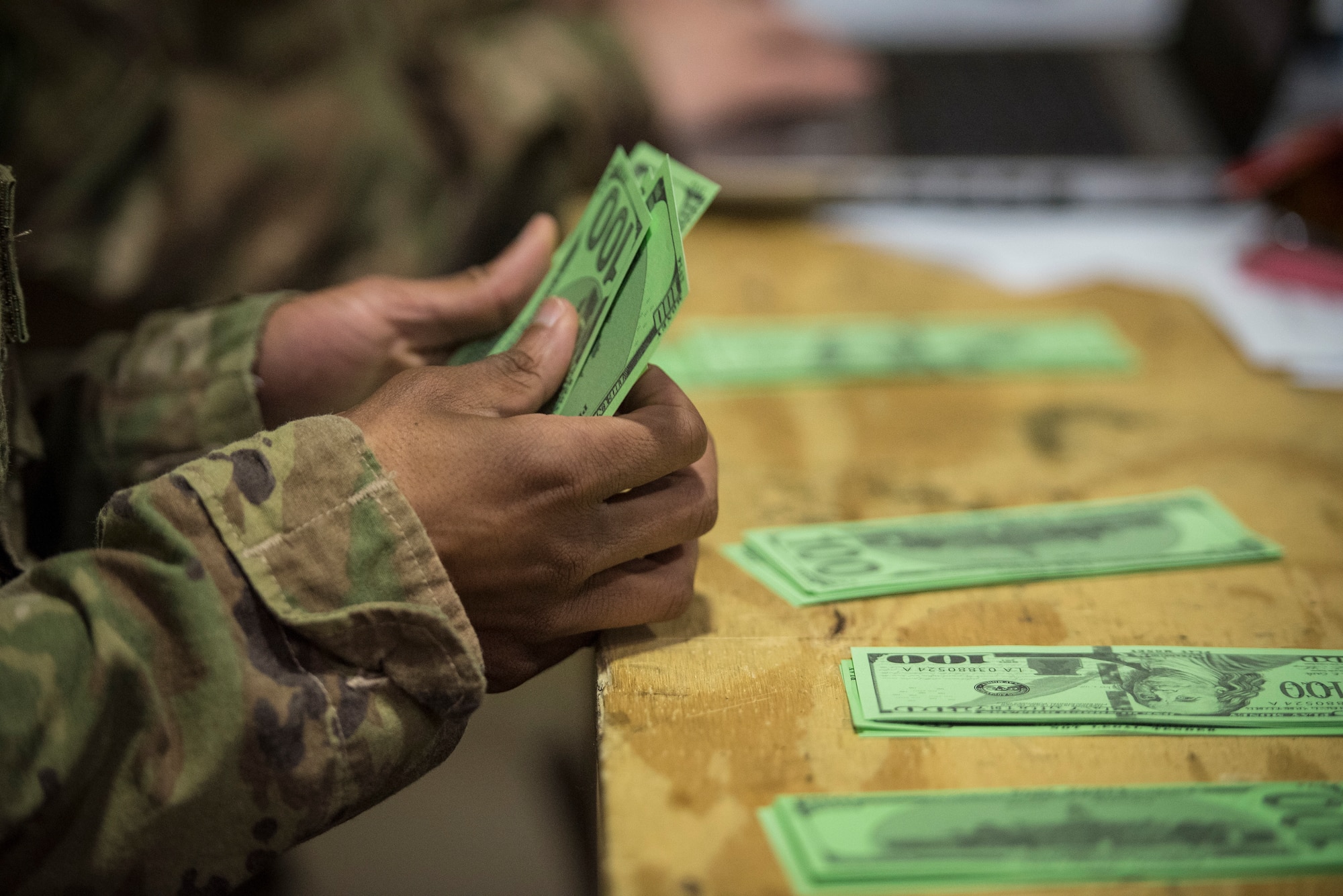 An Airman counts out fake money during a 27th Special Operations Comptroller Squadron and 27th Special Operations Contracting Squadron training exercise at Cannon Air Force Base, N.M., Apr. 18, 2019. Airmen were separated into different groups, balanced out and tasked to find solutions to mock-deployment situations created throughout the three-day training event. (U.S. Air Force photo by Senior Airman Lane T. Plummer)