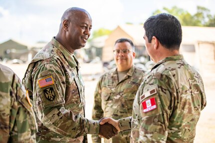 U.S. Army Maj. Gen. Sylvester Cannon, commander of the 167th Theater Sustainment Command (TSC), shakes hands with Peruvian army Lt. Col. Carlo Carrión, public affairs officer, during a visit to the Multinational Forces South headquarters for PANAMAX 2022 on Joint Base San Antonio - Fort Sam Houston, August 8, 2022.