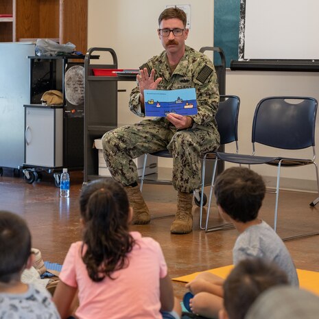 Builder Petty Officer 2nd Class Neil Kenefick, from the Junior Sailors Association (JSA) of Pearl Harbor Naval Shipyard and Intermediate Maintenance Facility (PHNSY & IMF) was one of several volunteers at the Aiea Public Library, July 22, 2022. 

The event was part of the association’s goal to reach out to neighboring communities and make a positive impact on local youth, according to HT2 Thomas Kozlowski, president of the JSA.

During the visit, the Sailors read several children's books and held interactive learning activities. Several PHNSY & IMF challenge coins were given to the children along with miniature American flags, whose ages ranged from 2 to 8 years old.

“After we read to the kids, we answered questions about our Navy careers, the different types of uniforms we wear and what it was like living on a boat,” Kozlowski said. “Overall, the Sailors, librarians and library staff agreed that it was a successful event.” (Official U.S. Navy photo by Dave Amodo)