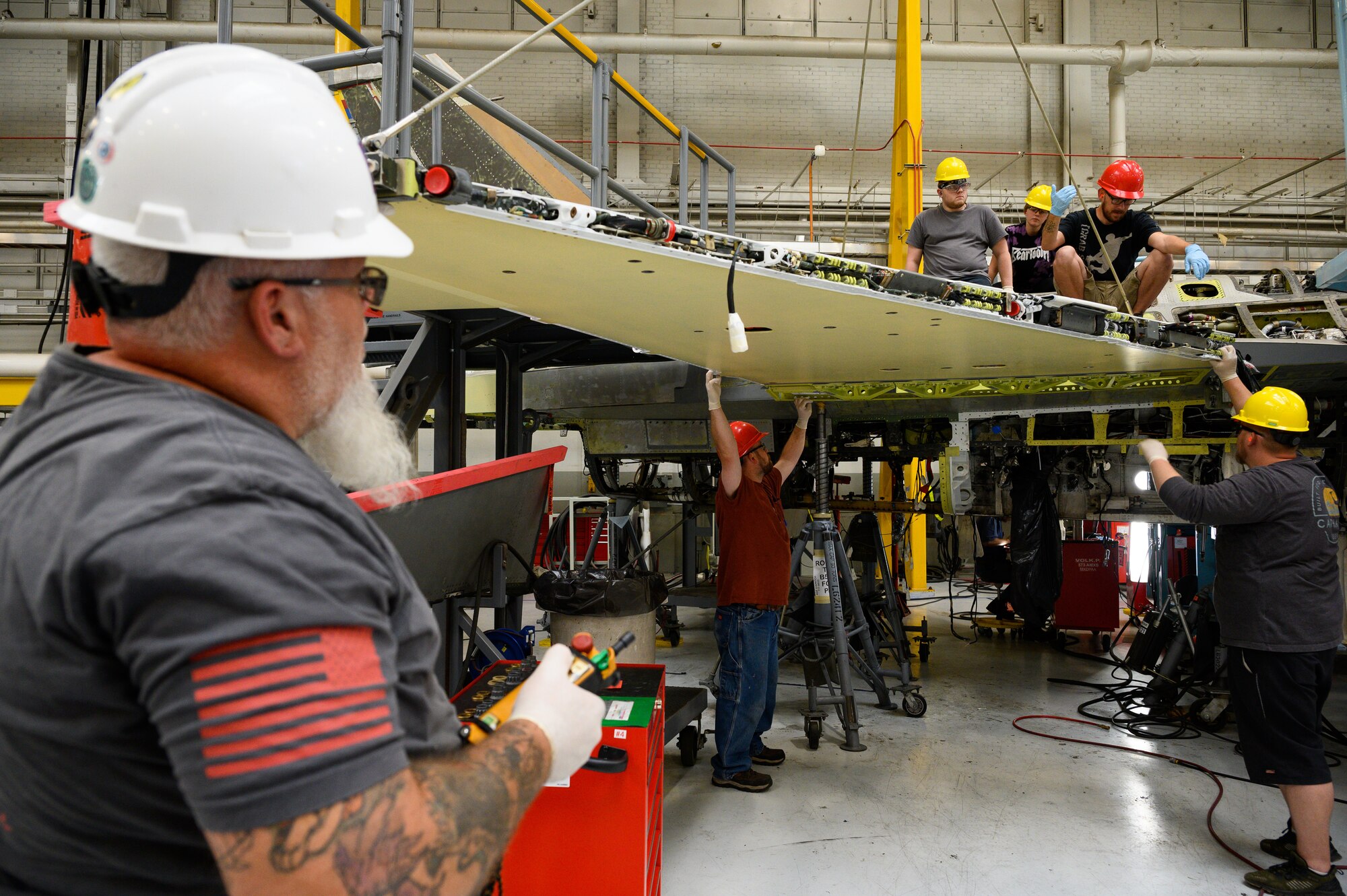 A 573rd Aircraft Maintenance Squadron crew prepares to install a wing onto an F-16 Fighting Falcon undergoing a Service Life Extension Program work package at Hill Air Force Base, Utah, Aug. 4, 2022.