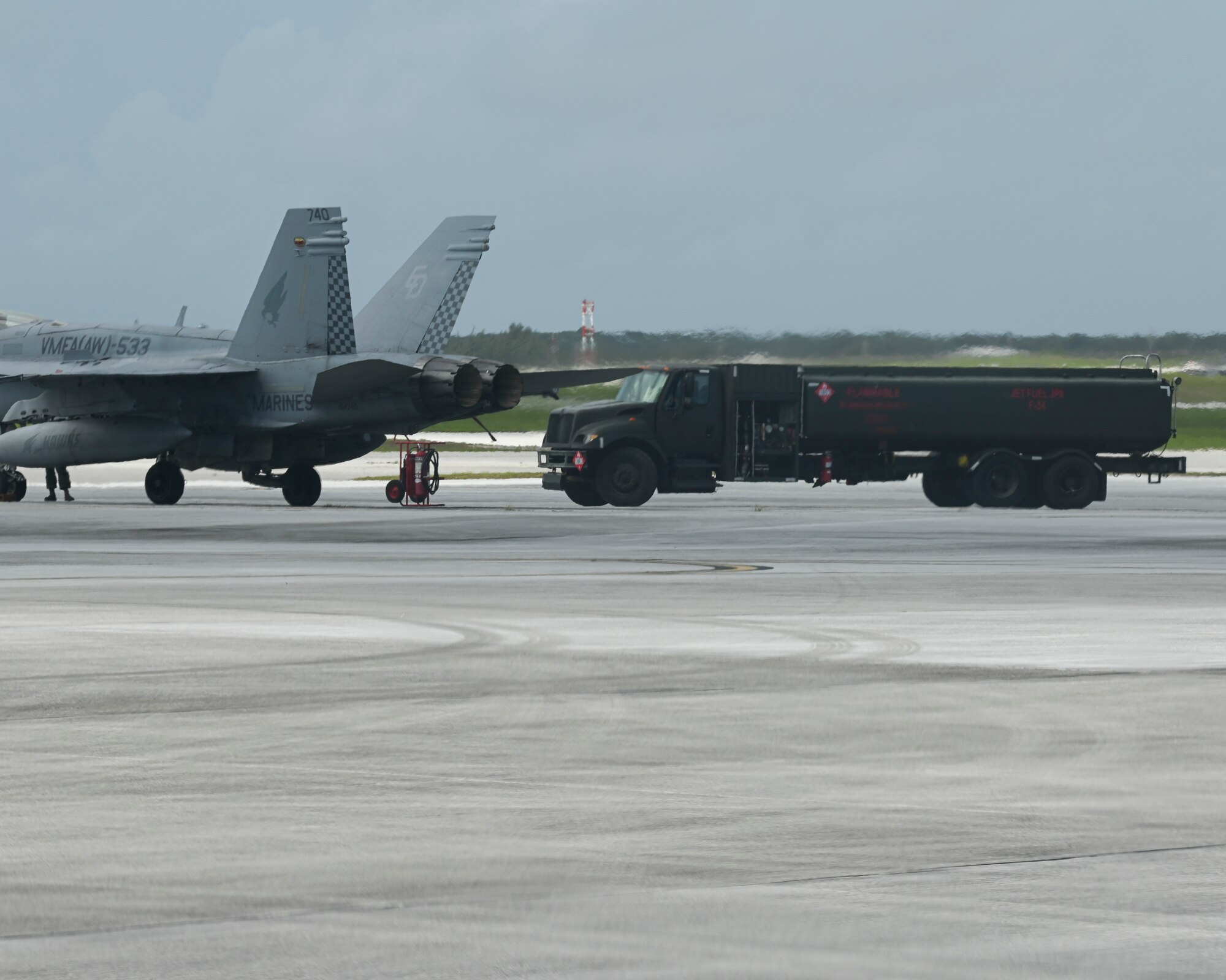 An R-11 Refueler approaches a U.S. Marine Corps F/A-18 Hornet to conduct a hot-pit refueling exercise on Andersen Air Force Base, Guam, Aug. 16, 2022. Hot-pit refueling is a term used for refueling an aircraft while its engines are running, which is a technique used to maximize efficiency and allow the aircraft to quickly take off. (U.S. Air Force photo by Airman Spencer Perkins)