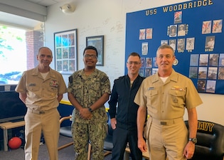 Naval Education and Training Command (NETC) Force Master Chief Matt Harris, Fire Controlman 2nd Class Marvin Tilghman, Sonar Technician (Surface) 2nd Class Marlin Boucher, and Rear Adm. Pete Garvin, NETC commander, pose for a photo at Navy Recruiting Station Woodbridge, Virginia, Aug. 16, 2022.