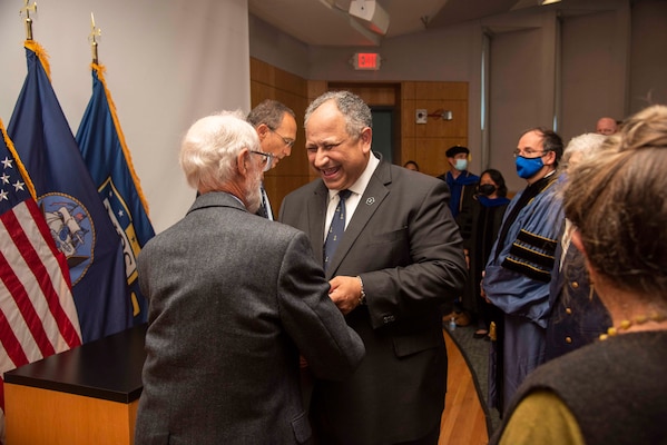 Secretary of the Navy Carlos Del Toro, right, embraces Professor Emeritus Dr. Rudy Panholzer, Del Toro's former professor and thesis advisor, during an award ceremony Aug. 18, 2022. Del Toro awarded Panholzer with the Distinguished Civilian Service Award for his life-long commitmne to the Naval Postgraduate School and to the DOD at large.