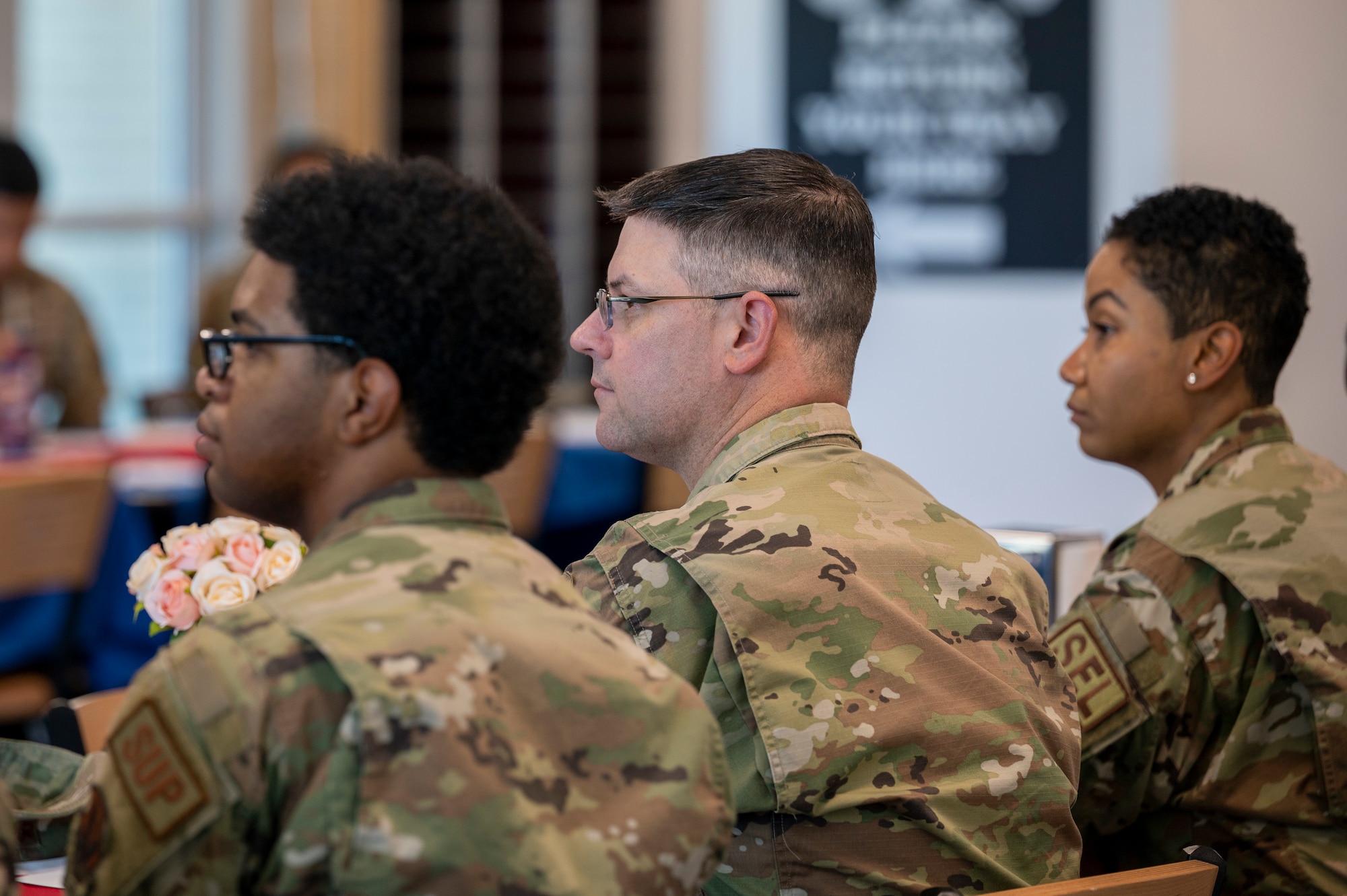 Airmen sit at a table