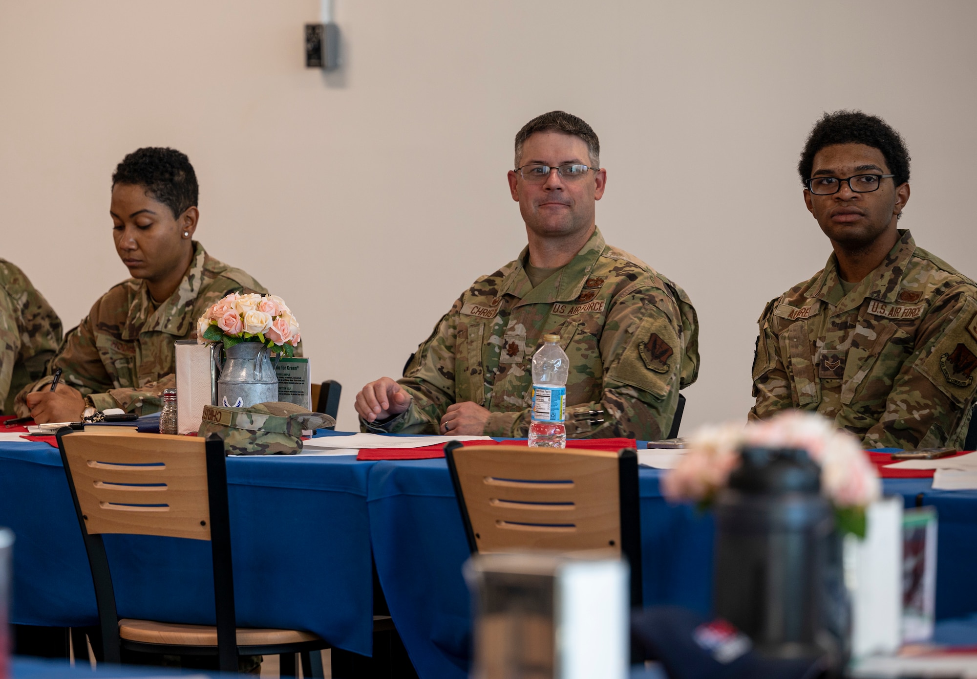 Airmen sit at a table