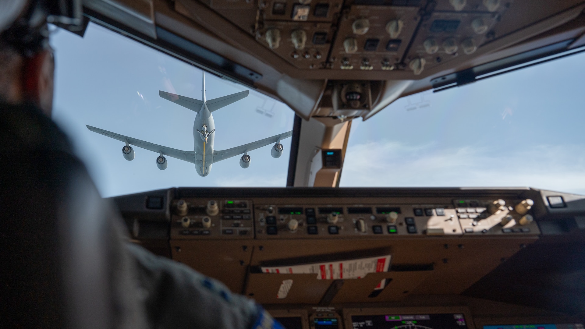 The view of a KC-135 through the cockpit of a KC-46.