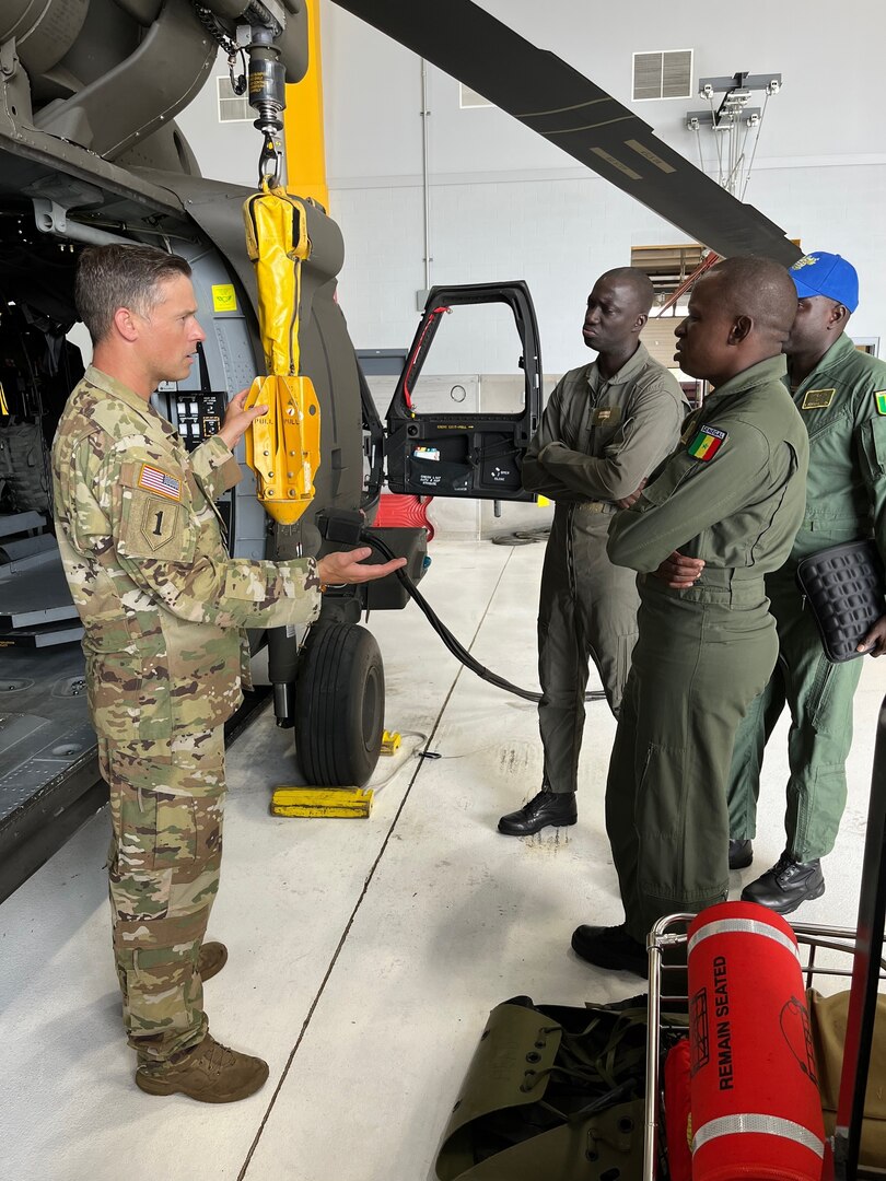 U.S. Army Chief Warrant Officer 4 George Vietje, Vermont Army National Guard, discusses hoist operations with fellow pilots from the Senegalese Air Force. The Vermont Army National Guard hosted 3 Senegalese Air Force pilots July 17-22, 2022, to conduct safety, operations, and maintenance cross-training with VTARNG’s Aviators during a State Partnership Program visit. The Department of Defense’s State Partnership Program pairs U.S. state National Guard units with other nations to facilitate international civil-military relationships. (U.S. Army National Guard photo by Sgt. 1st Class Jason Alvarez)