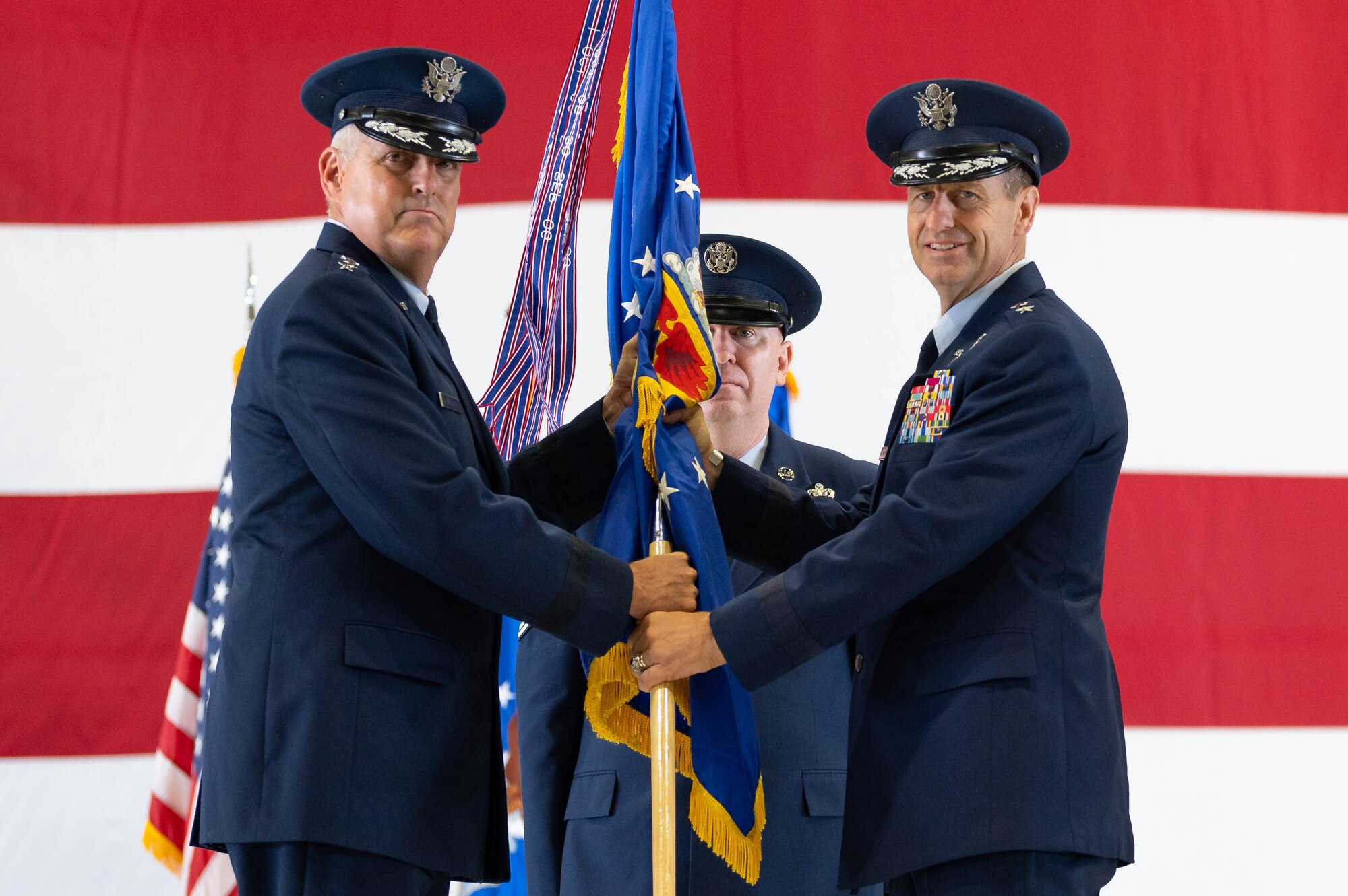 U.S. Air Force Gen. Mike Minihan, Air Mobility Command commander, gives guidon to Maj. Gen. Corey Martin during a change of command ceremony.
