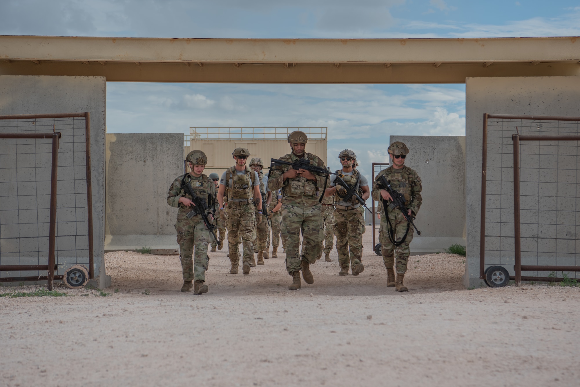 U.S. Air Force medical technicians and their armed escort initiate a foot patrol through the Gotham City military operations urban terrain training facility during the Medic Rodeo 2022 competition at Melrose Air Force Range, N.M., Aug. 17, 2022. Medic Rodeo 2022 incorporates MEDIC-X in scenarios for teams to test the new concept, while evaluating how best to prepare for future warfare where medics have to operate in degraded and geographically isolated environments.  (U.S. Air Force photo by Airman 1st Class Mateo Parra)