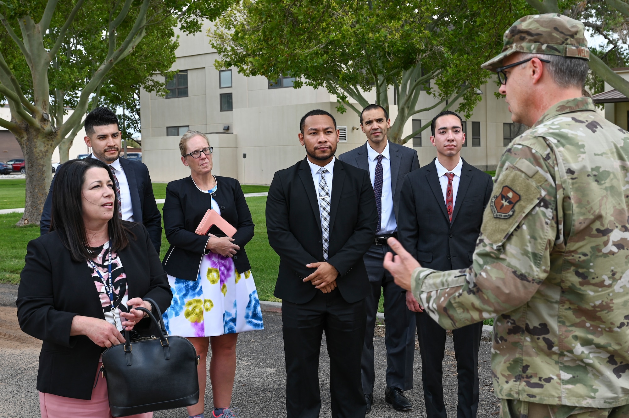 A group of people meet a military member.