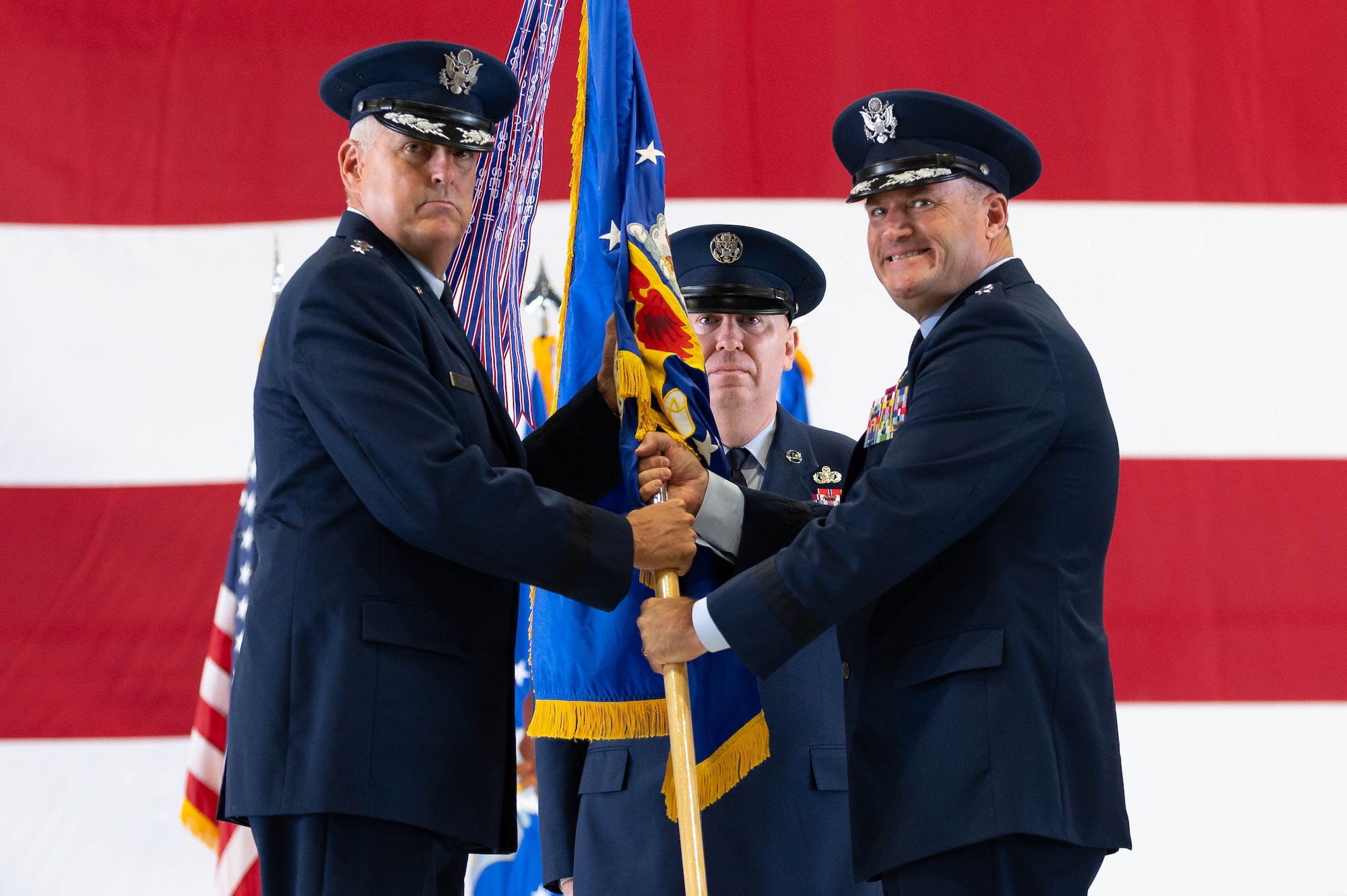 U.S. Air Force Gen. Mike Minihan, Air Mobility Command commander, takes guidon from Maj. Gen. Kenneth Bibb Jr., outgoing 18th Air Force commander, during a change of command ceremony