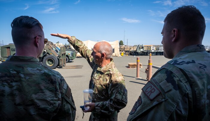 Royal Air Force Corp. Brian Bufton, middle, a movement technician assigned to the 4624th Air Movements Squadron at Royal Air Force Brize Norton, Oxfordshire, England, talks about the aerial porter job at the Global Readiness Deployment Center on Travis Air Force Base, California, August 2, 2022. Bufton explained the similarities and differences between his job and U.S. Air Force's aerial porter job with two Airmen assigned to USAF's 621st Contingency Response Wing. (U.S. Air Force photo by Staff Sgt. Scott Warner)