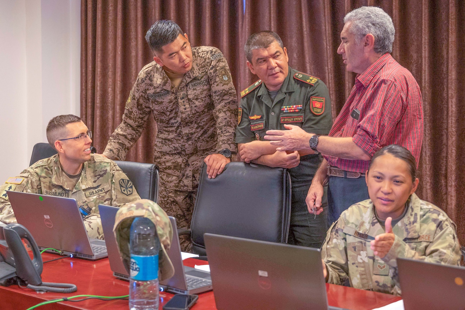 Maj. Michael Wasmundt, Arizona Army National Guard Deputy State Surgeon of Clinical, communicates via an interpreter with officers from Mongolia and the Kyrgyz Republic, while Arizona Air National Guard Senior Airman Ethel Redor, a ground transportation support officer with the 161st Air Refueling Wing, works with her counterparts during Exercise REGIONAL COOPERATION 22. (U.S. Air National Guard photo by Maj. Angela Walz)